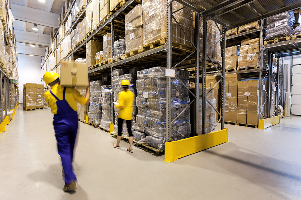 Workers stock shelves at a warehouse